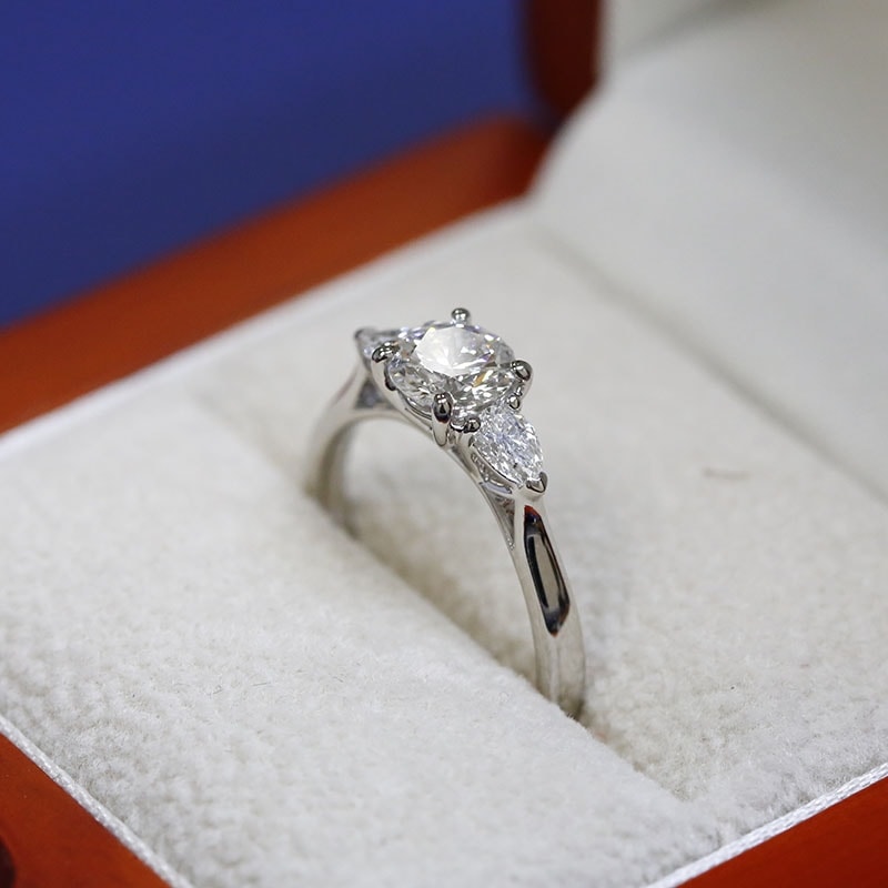 Round Cut and Pair of Pear Shape Side Stones Diamond Engagement Ring in a Box
